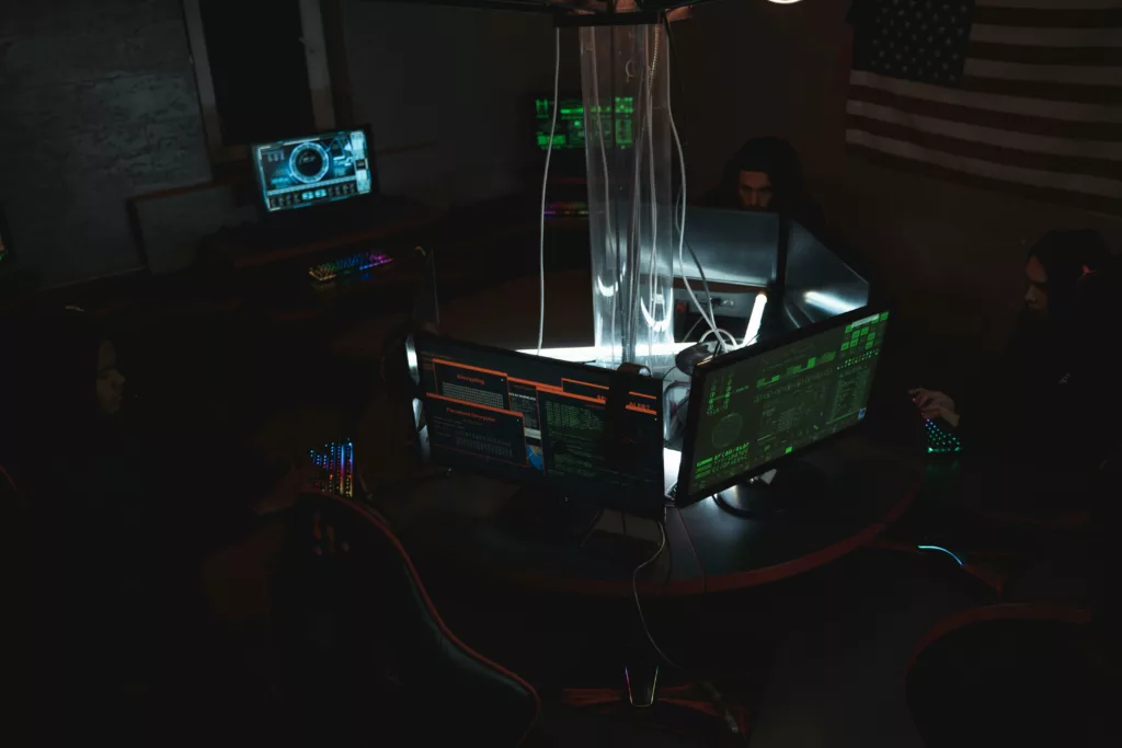 Cyberattaque ou centre de sécurité militaire sombre avec des écrans d'ordinateur lumineux et des personnes travaillant dans l'obscurité.